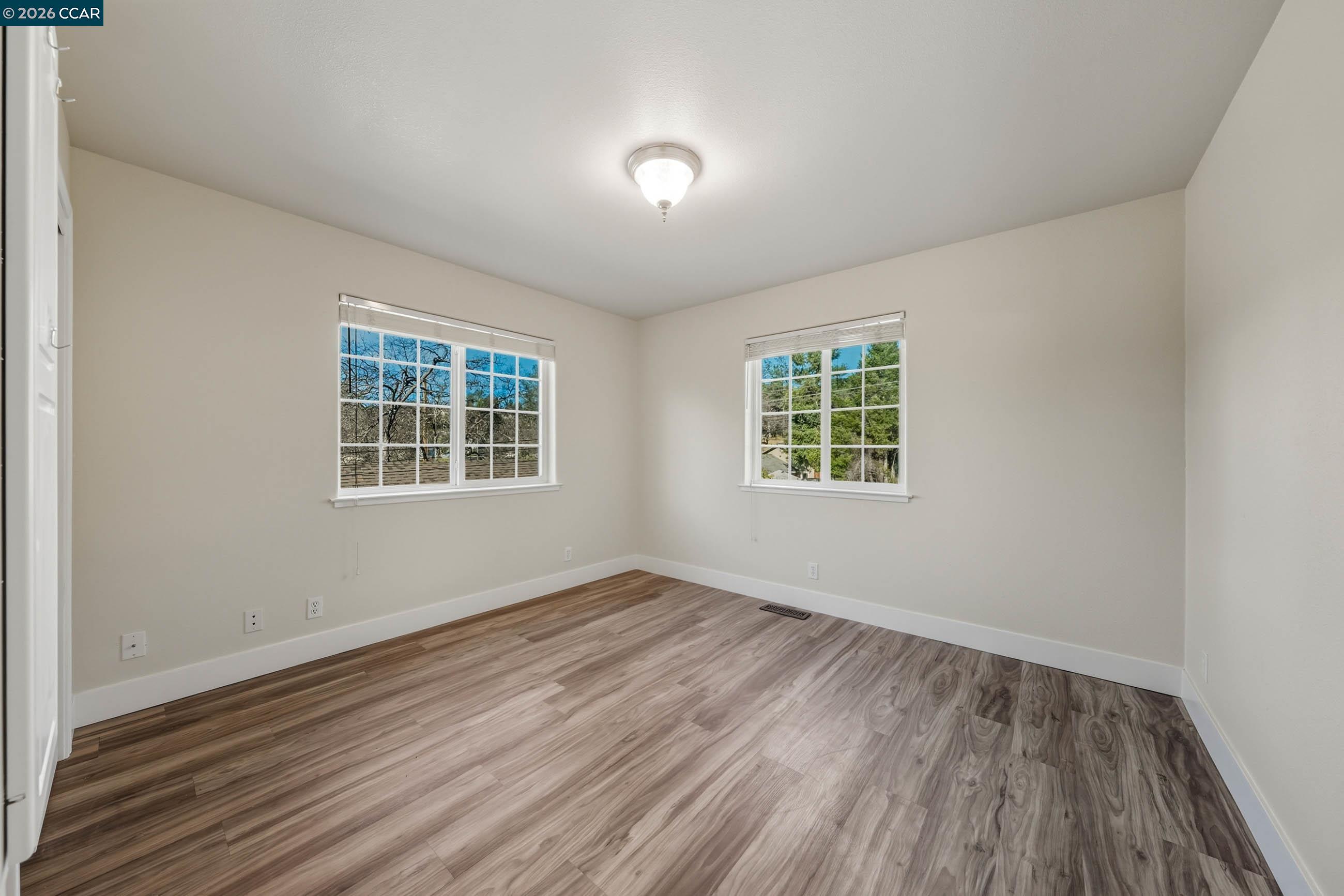 18357 Deer Hill Road Hidden Valley Lake, CA 95467 - Photo 24 of 29 an empty room with wooden floor and windows