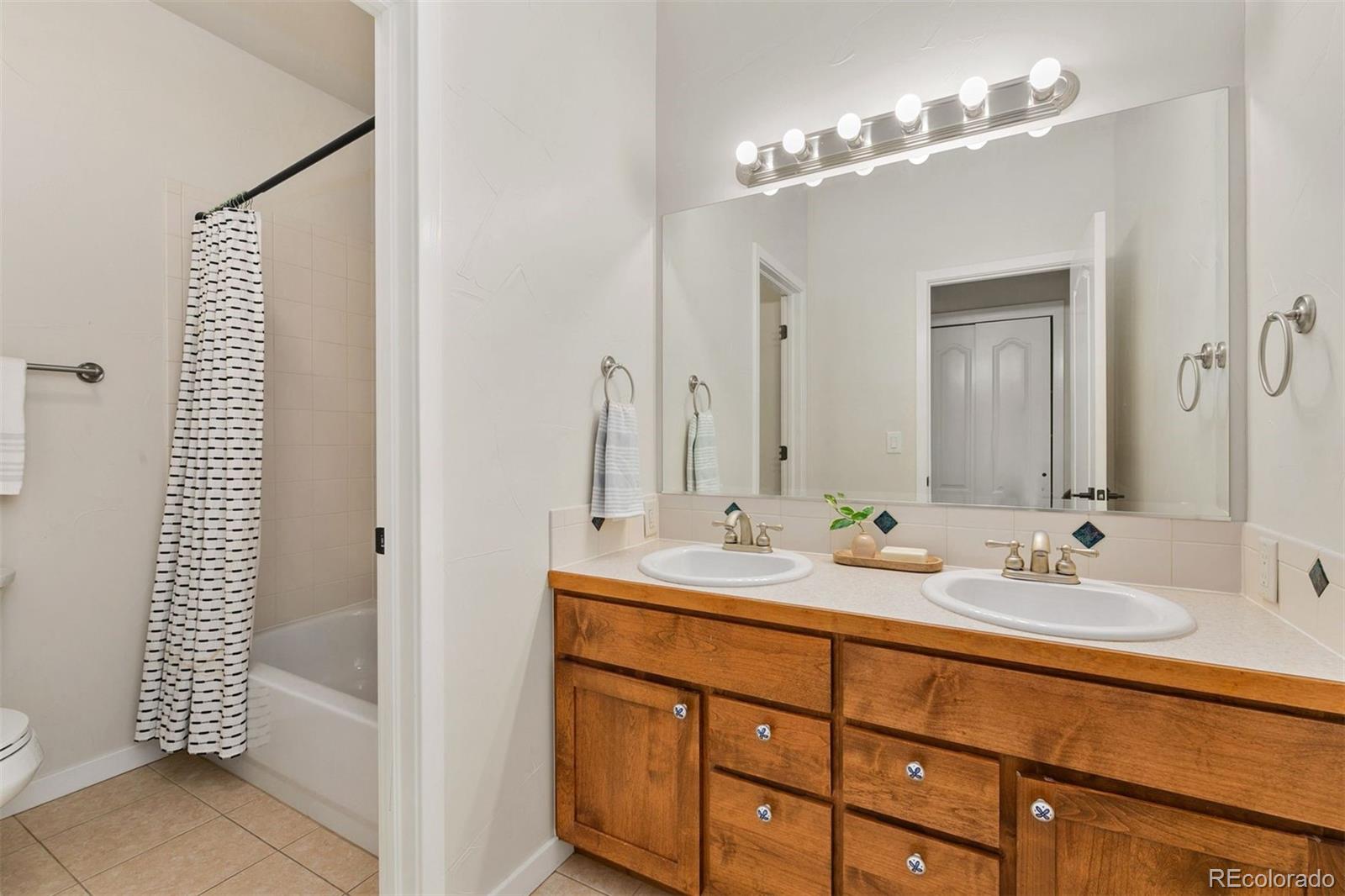 8440 Spinnaker Bay Drive Windsor, CO 80528 - Photo 21 of 36 a bathroom with a sink double vanity and a mirror