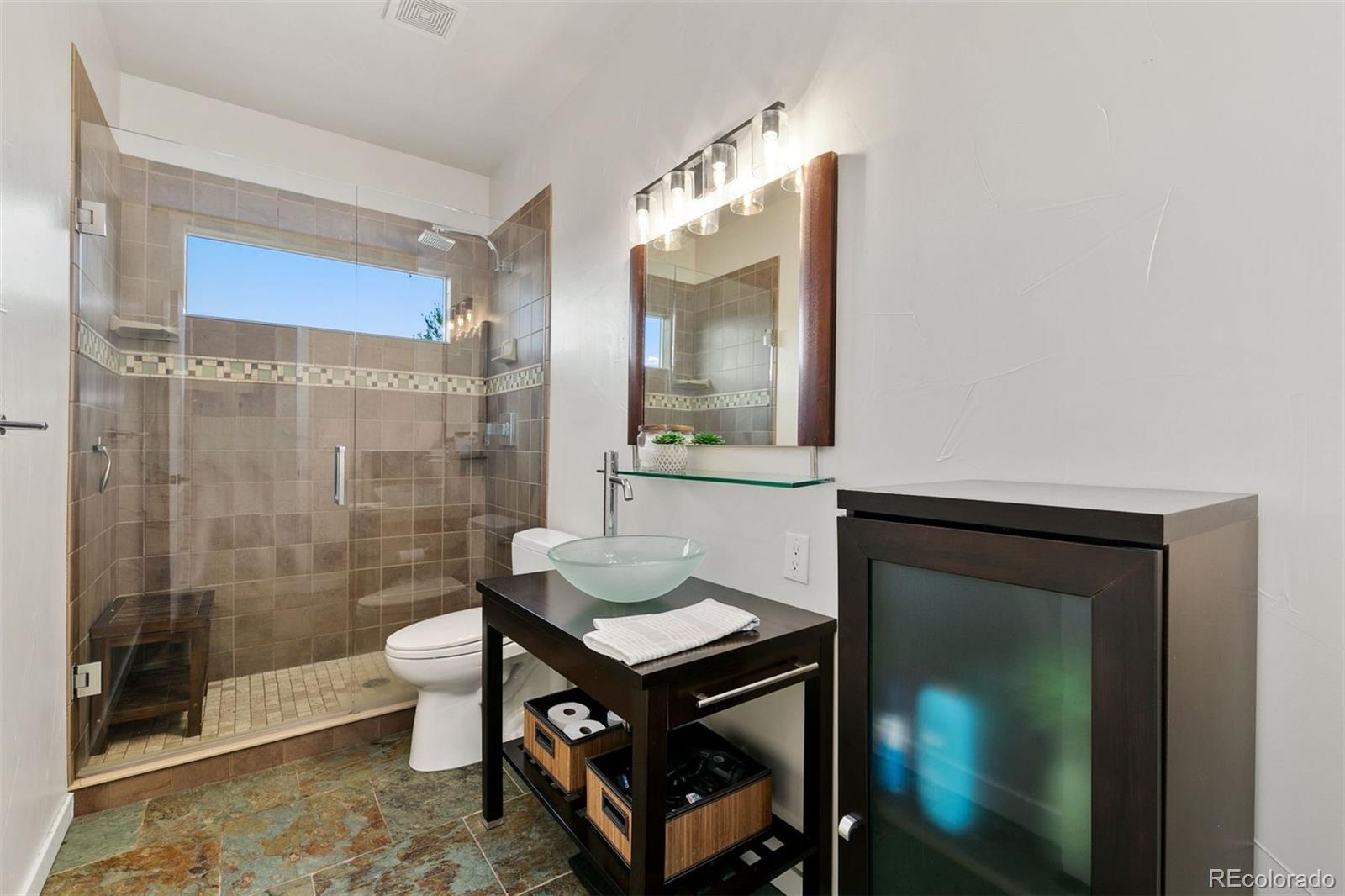 8440 Spinnaker Bay Drive Windsor, CO 80528 - Photo 23 of 36 a bathroom with a sink mirror toilet and shower