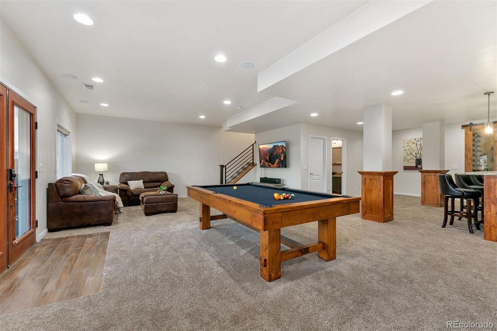 8440 Spinnaker Bay Drive Windsor, CO 80528 - Photo 24 of 36 a living room with furniture pool table and windows