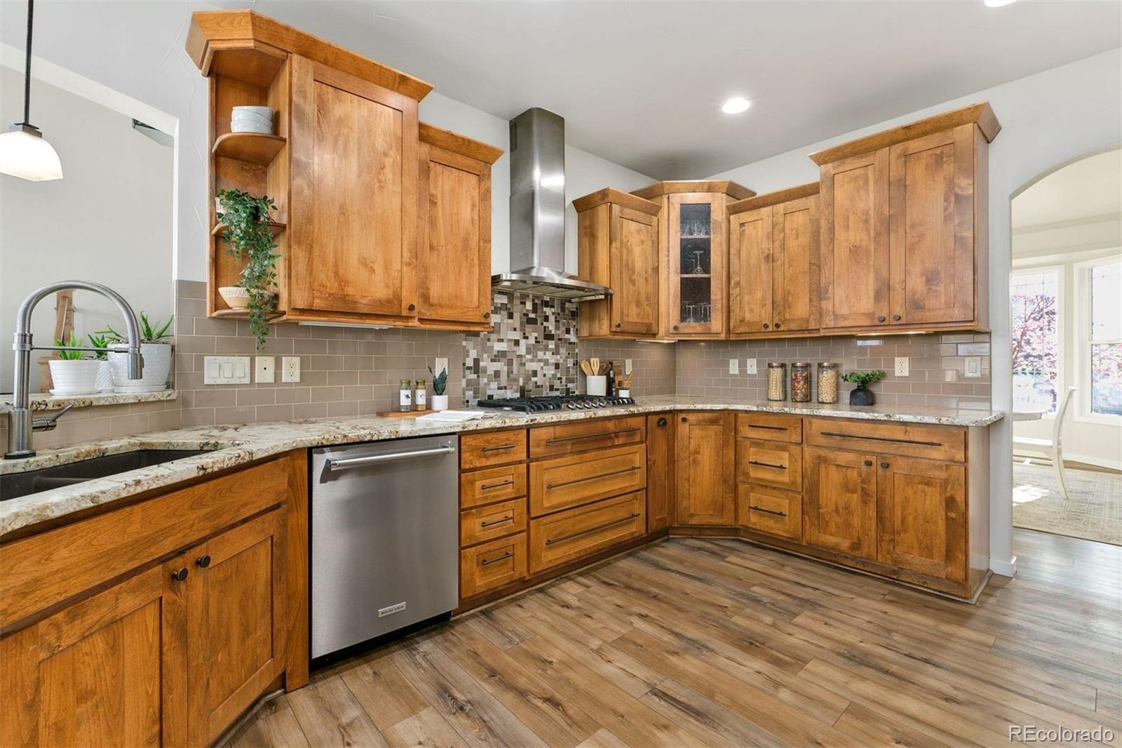 8440 Spinnaker Bay Drive Windsor, CO 80528 - Photo 6 of 36 a kitchen with stainless steel appliances granite countertop a sink a stove cabinets and wooden floor