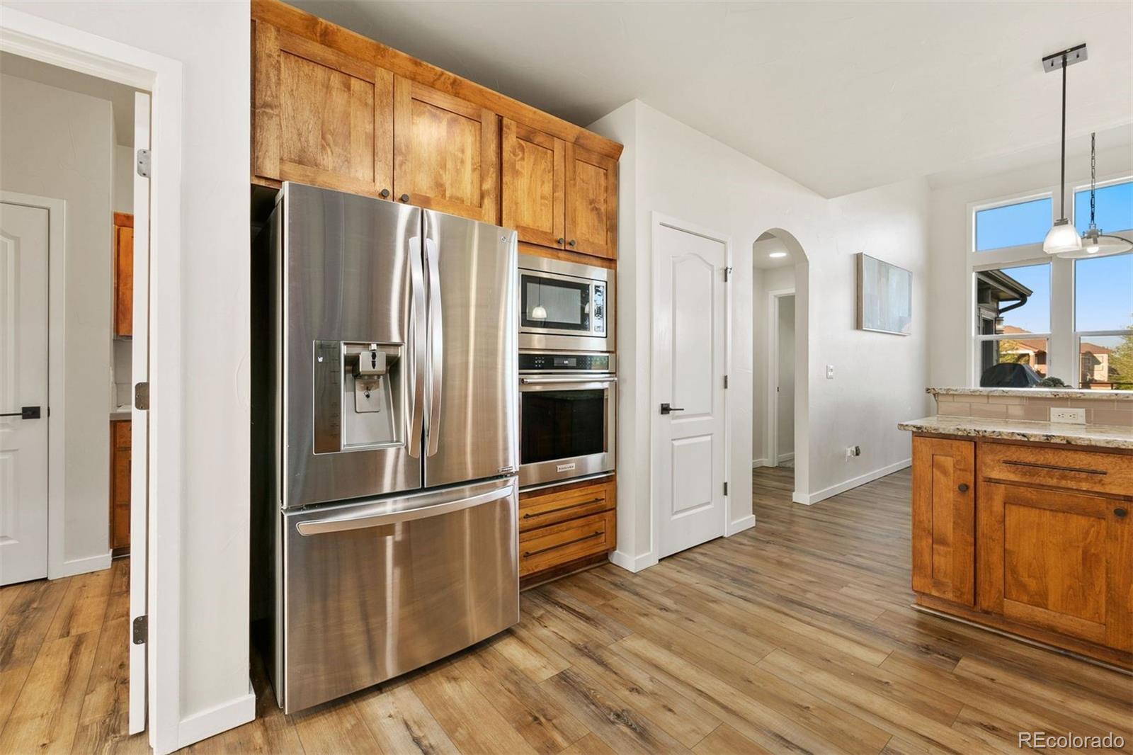 8440 Spinnaker Bay Drive Windsor, CO 80528 - Photo 7 of 36 a kitchen with stainless steel appliances wooden floor and a refrigerator