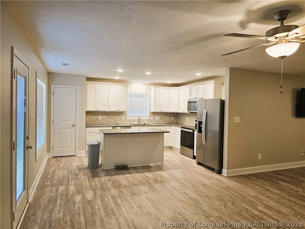 422 Mitchell Farm Road Goldsboro, NC 27530 - Photo 18 of 28 a kitchen with stainless steel appliances kitchen island granite countertop a refrigerator and a sink