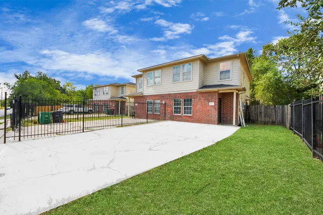 a view of an house with backyard and a tree