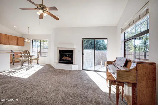 a living room with furniture a fireplace and a floor to ceiling window