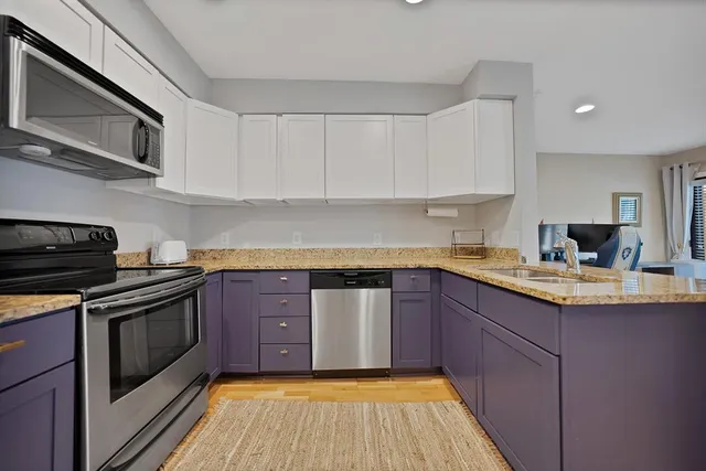a kitchen with stainless steel appliances granite countertop a sink a stove and a refrigerator