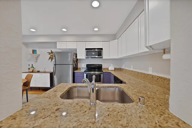 a kitchen with granite countertop stainless steel appliances and wooden cabinets