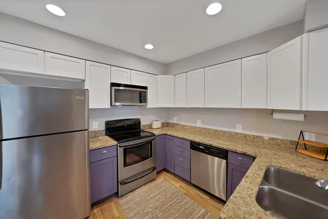 a kitchen with granite countertop a sink stove and cabinets