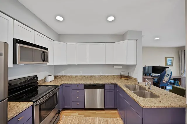 a kitchen with stainless steel appliances granite countertop a refrigerator sink and stove