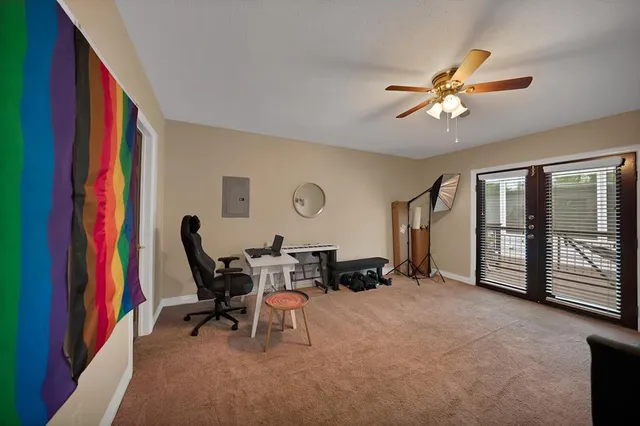 a living room with furniture and a fan