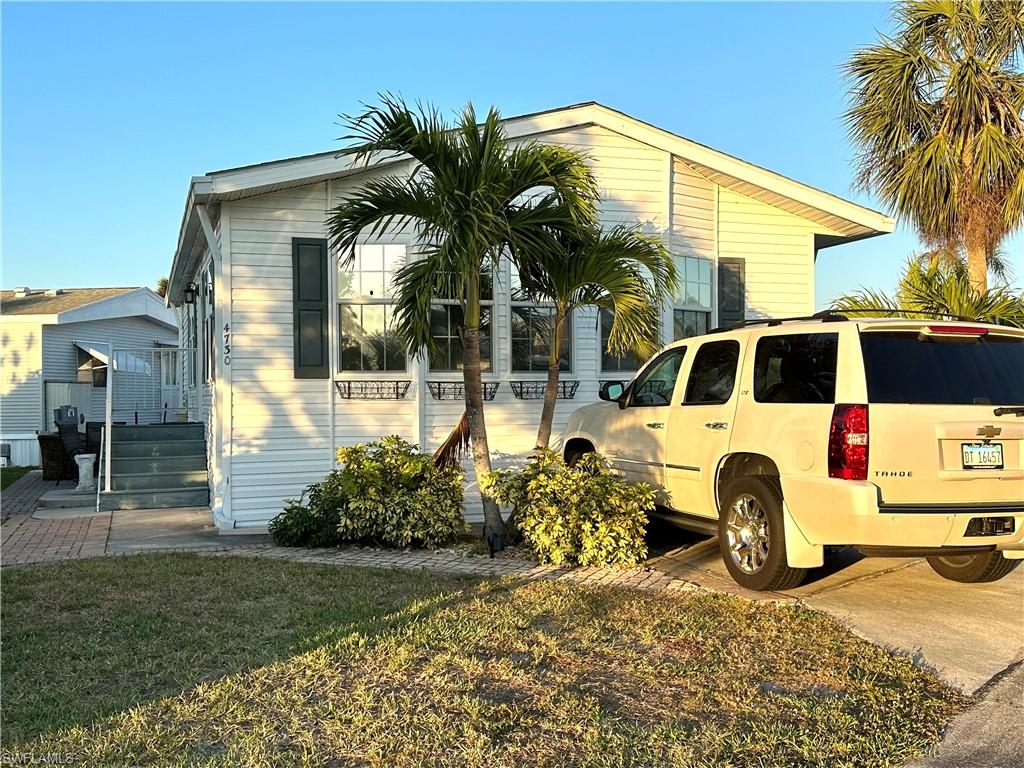 a view of a white house with large windows and a table and chairs