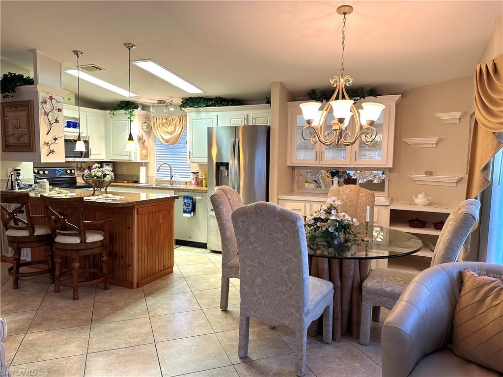 4730 Lantern Lane West Estero, FL 33928 - Photo 12 of 22 a view of a dining room and livingroom with furniture a chandelier and kitchen view