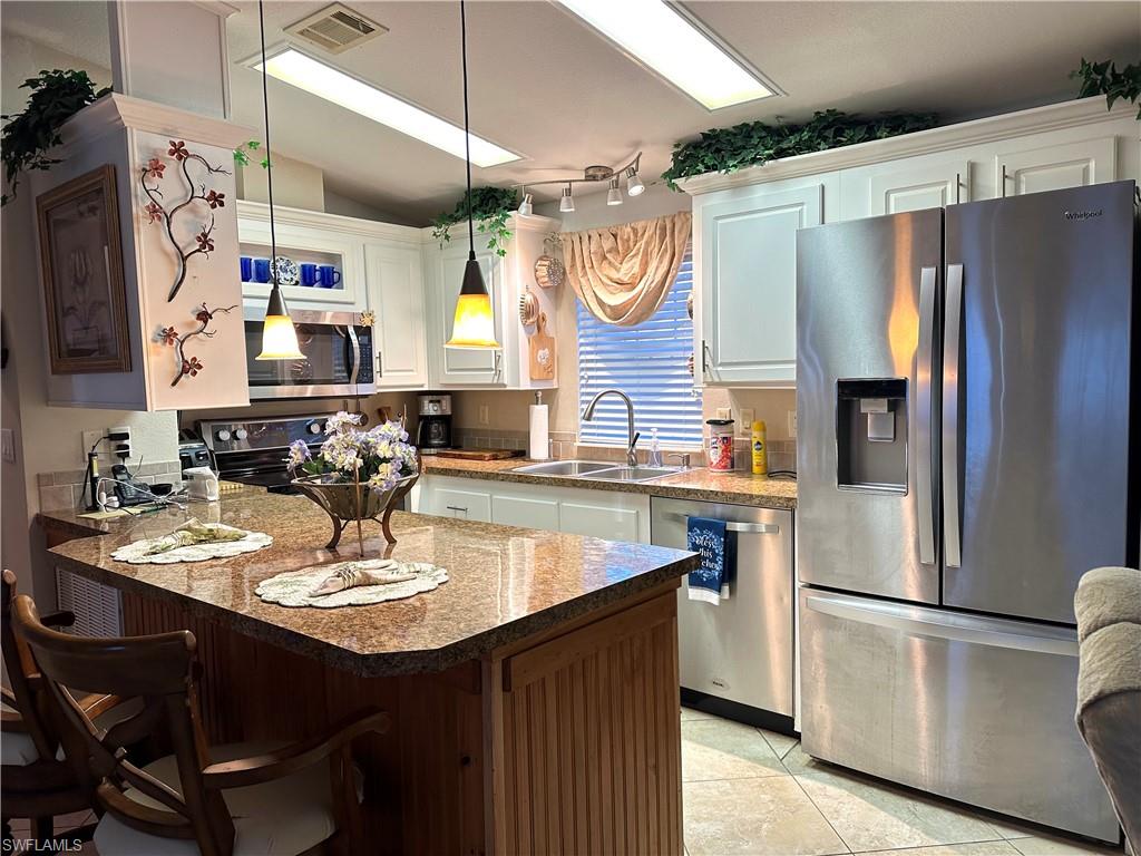 4730 Lantern Lane West Estero, FL 33928 - Photo 5 of 22 a kitchen with refrigerator and cabinets