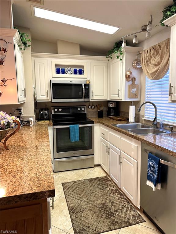 4730 Lantern Lane West Estero, FL 33928 - Photo 6 of 22 a kitchen with stainless steel appliances granite countertop a stove a sink and a microwave