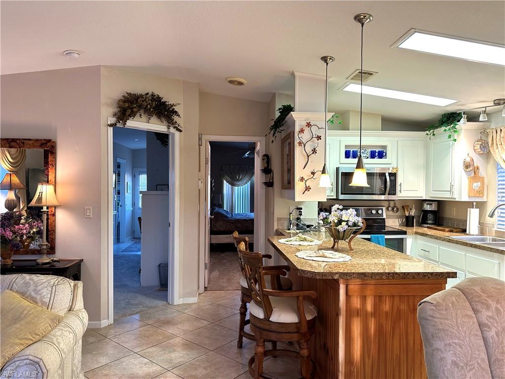 4730 Lantern Lane West Estero, FL 33928 - Photo 8 of 22 a view of a dining room and livingroom with furniture wooden floor a chandelier