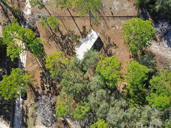 a view of a hallway with wooden floor and a bathroom