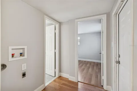 a view of a hallway with wooden floor