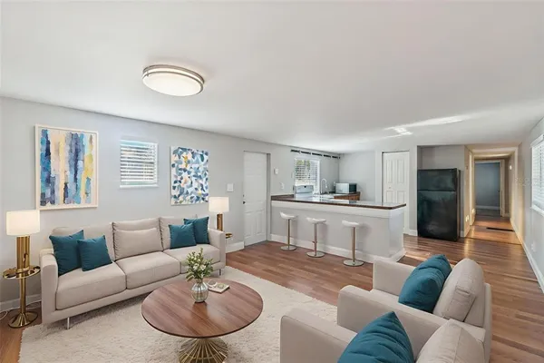 a living room with furniture and a view of kitchen