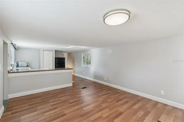 a view of a room with wooden floor and a window