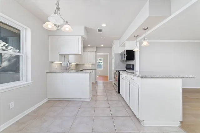 a large kitchen with a large counter top appliances and cabinets
