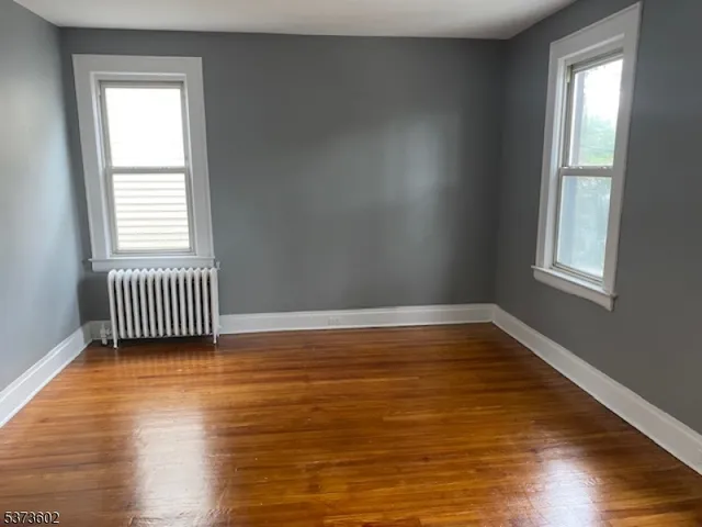 a view of a room with wooden floor and a window
