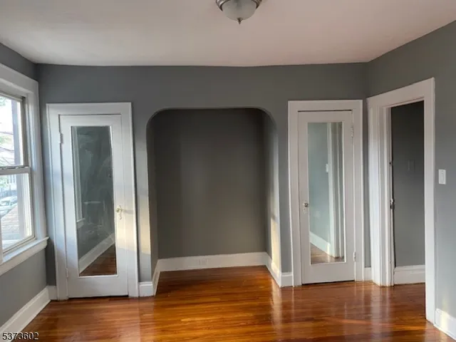 a view of a livingroom with wooden floor and a window