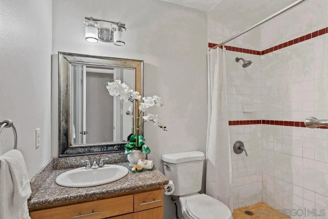 1445 Ronda Place Escondido, CA 92027 - Photo 7 of 15 a bathroom with a granite countertop sink toilet a mirror and shower