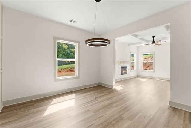 an empty room with wooden floor cabinet and windows
