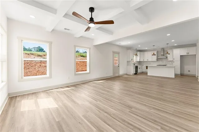 a view of empty room with wooden floor and window