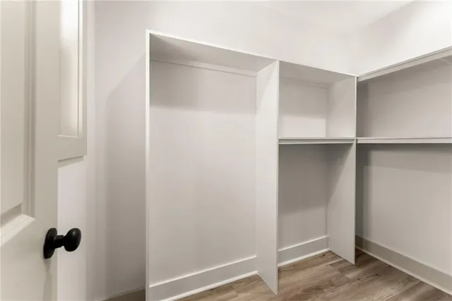 a view of walk in closet with empty racks