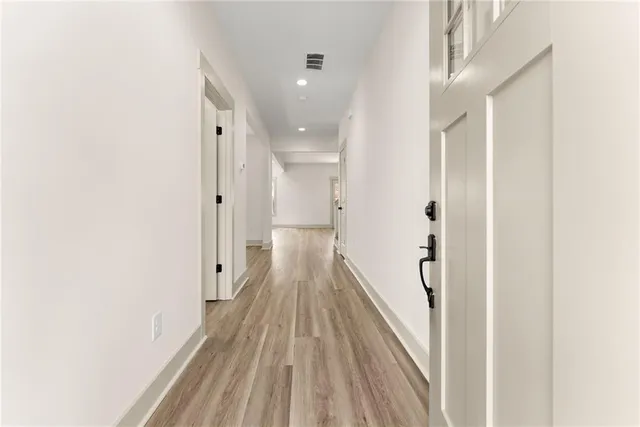 a view of a hallway with wooden floor and staircase