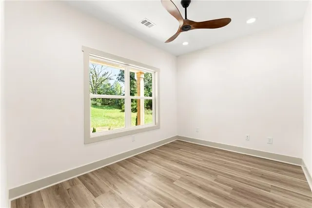 an empty room with a window and a ceiling fan