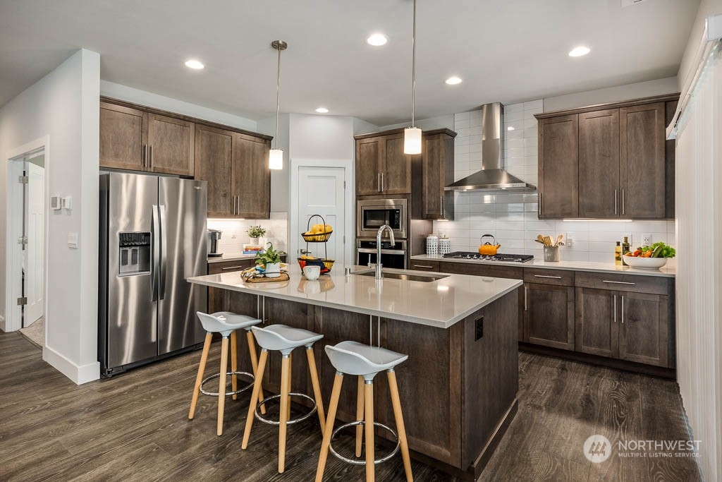 21535 6th Drive Southeast, Unit RM15 Bothell, WA 98021 - Photo 5 of 26 a kitchen with kitchen island granite countertop wooden floor cabinets and appliances