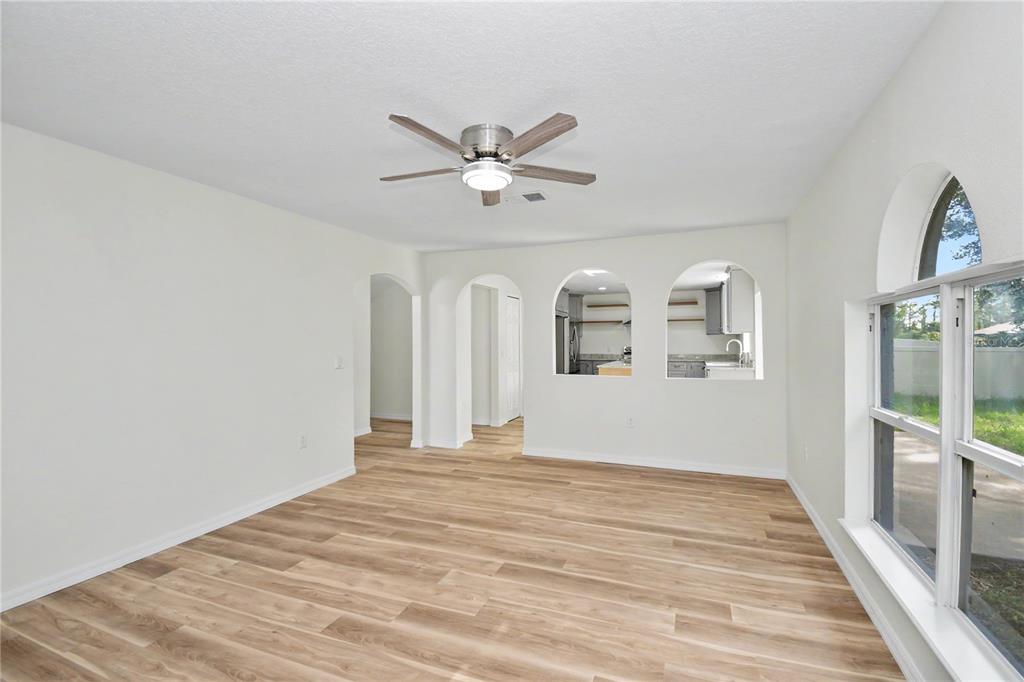 4948 Cromey Road North Port, FL 34288 - Photo 13 of 30 a view of a livingroom with wooden floor and a ceiling fan