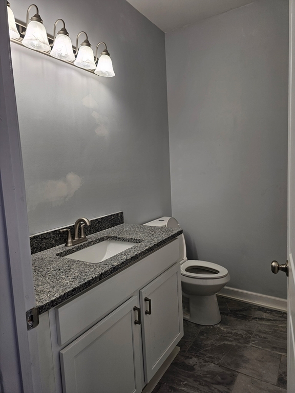 88 Stafford Holland Road Wales, MA 01081 - Photo 17 of 31 a bathroom with a granite countertop sink a toilet and a mirror
