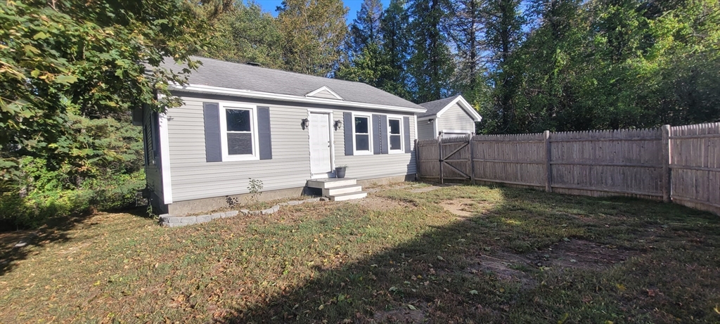 a white house that has tree in front of it