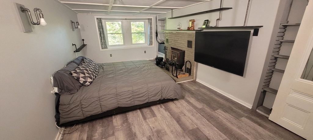 123 West River Road Hooksett, NH 03106 - Photo 21 of 40 a bed sitting in a bedroom next to a window with a fireplace