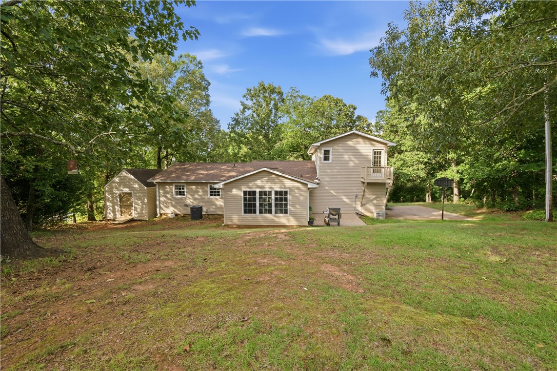 2001 Ridgeview Lane Seneca, SC 29678 - Photo 2 of 27 A private backyard oasis featuring a sprawling lawn, mature trees, and a detached shed.