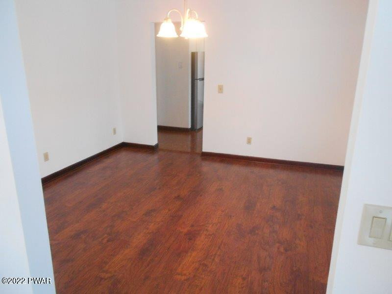 126 Maple Ridge Drive Hawley, PA 18428 - Photo 15 of 40 an empty room with wooden floor and windows