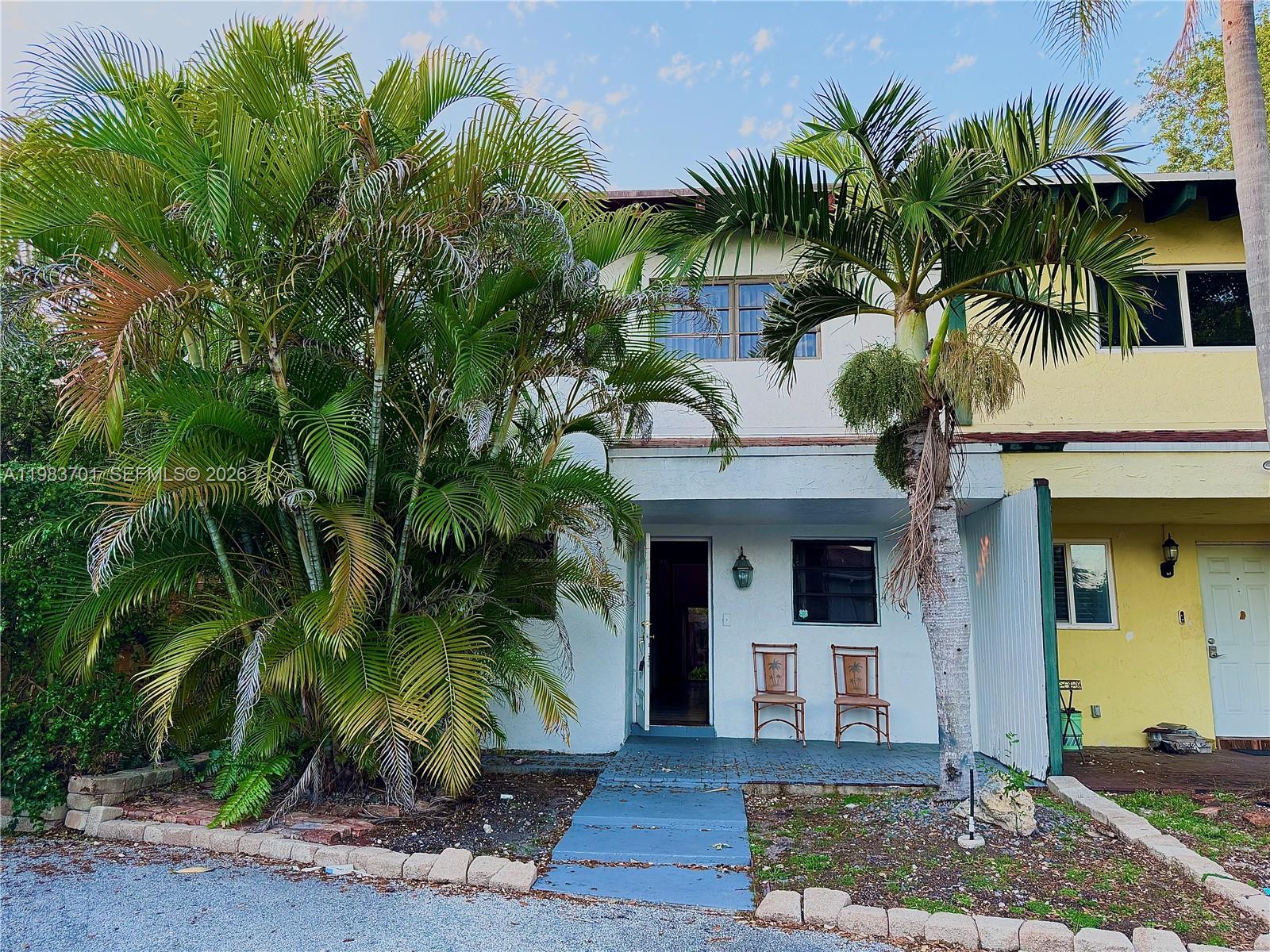 a front view of a house with a tree