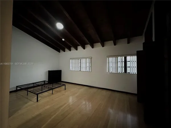 a room with wooden floor and a window