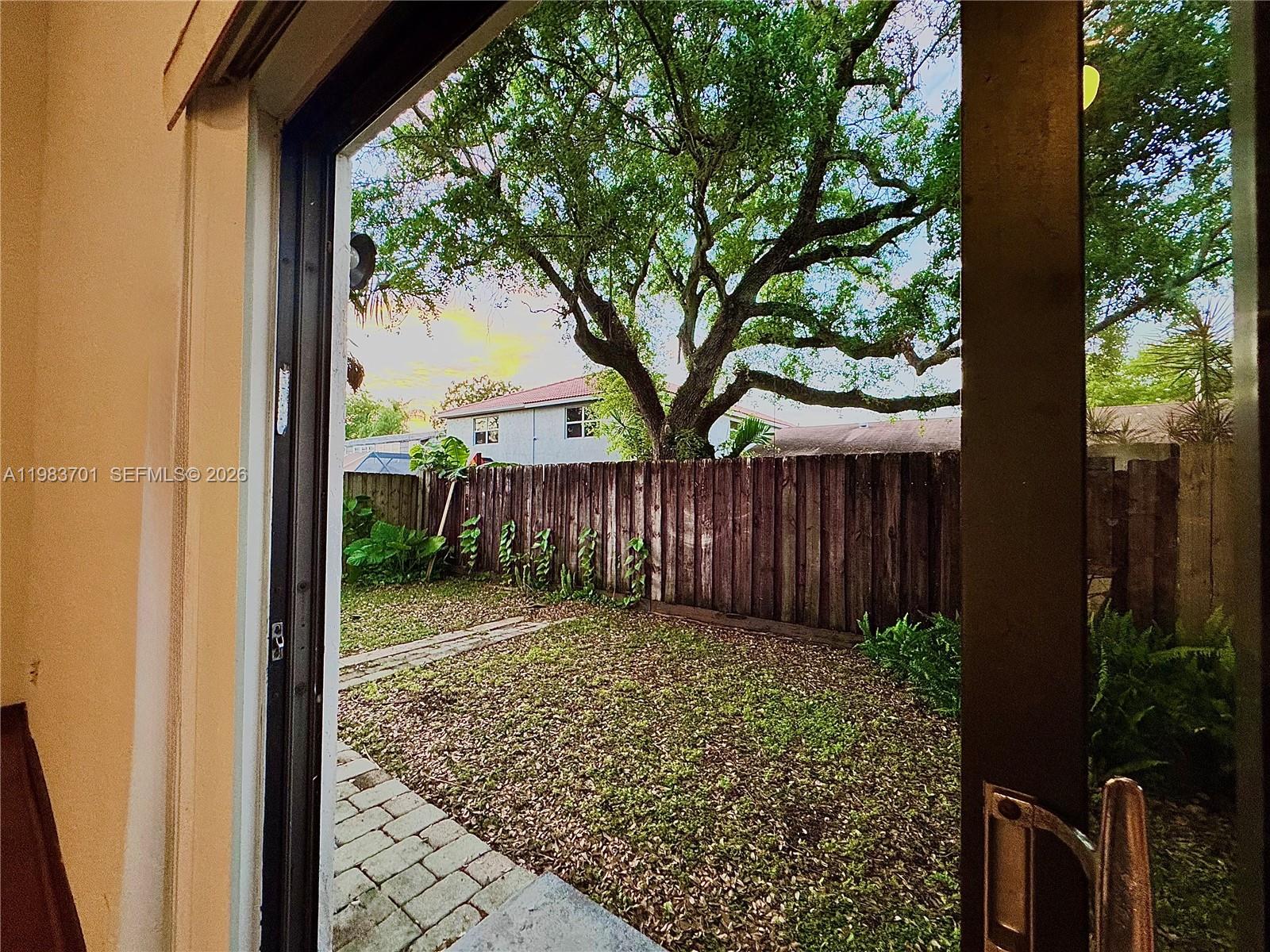 3911 Farragut Street Hollywood, FL 33021 - Photo 23 of 26 a view of a backyard with large trees and wooden fence