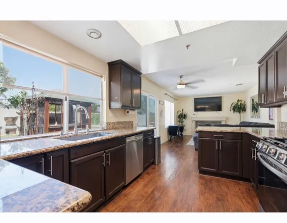 a large kitchen with stainless steel appliances lots of counter space and wooden floor