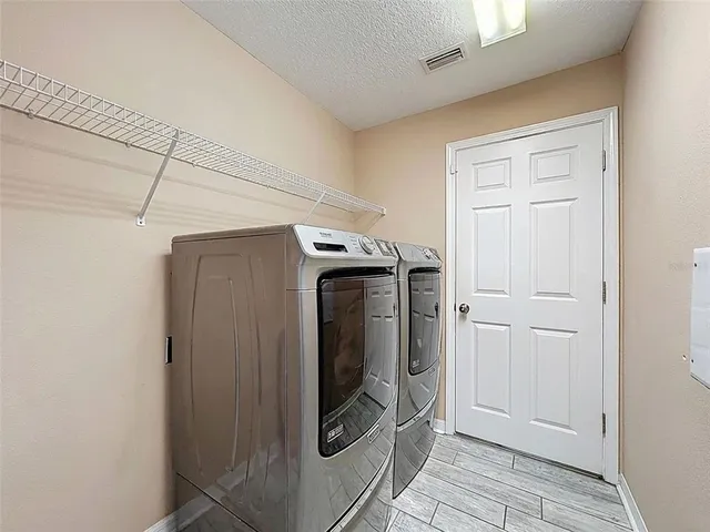 an empty room with wooden floor and a ceiling fan