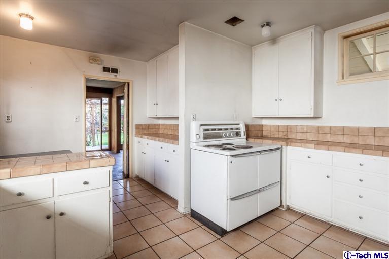 2924 Lombardy Road Pasadena, CA 91107 - Photo 13 of 20 a kitchen with granite countertop white cabinets and white appliances