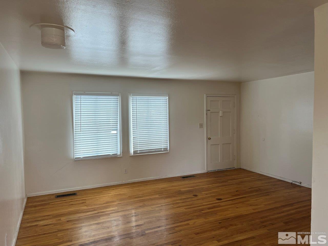 1240 Wesley Drive Reno, NV 89503 - Photo 7 of 17 an empty room with wooden floor and windows