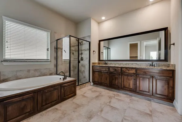 a spacious bathroom with a granite countertop tub sink and mirror