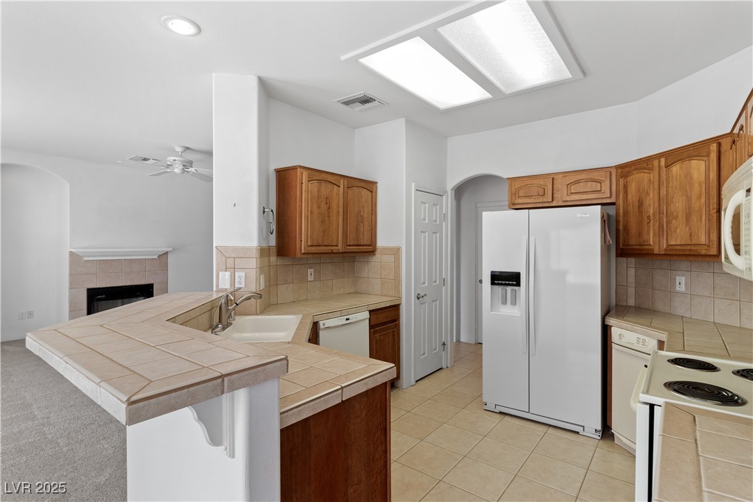 1200 Golf Club Drive Laughlin, NV 89029 - Photo 14 of 87 Kitchen featuring a peninsula, arched walkways, white appliances, a ceiling fan, and light tile patterned floors