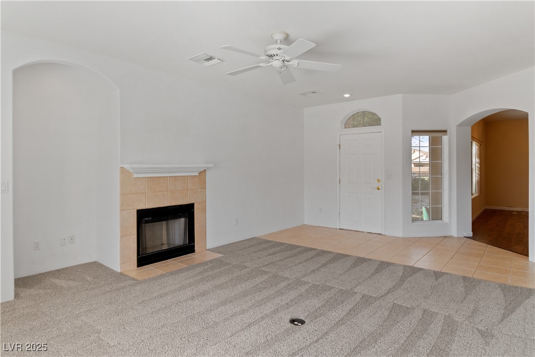 1200 Golf Club Drive Laughlin, NV 89029 - Photo 6 of 87 living room with carpet floors, arched walkways, ceiling fan, a tile fireplace, and tile patterned flooring