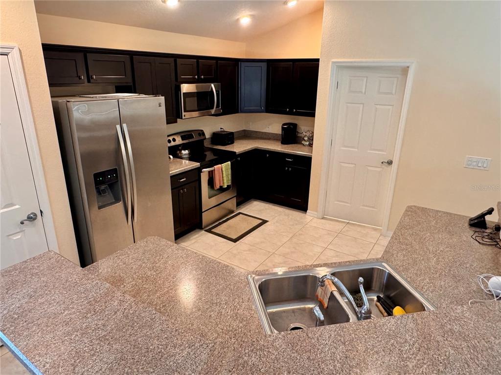2184 Markridge Loop The Villages, FL 32162 - Photo 10 of 35 a kitchen with stainless steel appliances kitchen island a refrigerator sink and stove